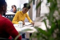 Young african american businesswoman writing on document while discussing with businessman at office Royalty Free Stock Photo