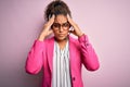 Young african american call center agent girl wearing glasses working using headset suffering from headache desperate and stressed Royalty Free Stock Photo