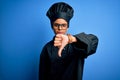 Young african american chef woman wearing cooker uniform and hat over blue background looking unhappy and angry showing rejection Royalty Free Stock Photo