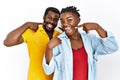 Young african american couple wearing casual clothes smiling cheerful showing and pointing with fingers teeth and mouth