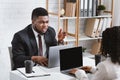 Young African American coworkers having argument at workplace, blank space Royalty Free Stock Photo