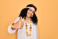 Young african american curly hippie woman wearing sunglasses and vintage accessories doing happy thumbs up gesture with hand