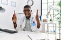 Young african american doctor man holding electronic cigarette at medical clinic celebrating victory with happy smile and winner Royalty Free Stock Photo