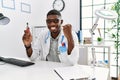 Young african american doctor man holding electronic cigarette at medical clinic screaming proud, celebrating victory and success Royalty Free Stock Photo