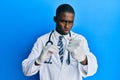 Young african american doctor man holding syringe annoyed and frustrated shouting with anger, yelling crazy with anger and hand Royalty Free Stock Photo