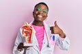 Young african american doctor woman holding anatomical model of respiratory system smiling happy and positive, thumb up doing