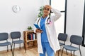 Young african american doctor woman at waiting room stressed and frustrated with hand on head, surprised and angry face Royalty Free Stock Photo