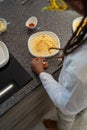 Young African-American With Dreadlocks In The Hair. He is preparing hummus in a modern kitchen