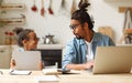 Young african american father works remotely on laptop while his little son using digital tablet Royalty Free Stock Photo