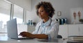 Young African-American female doctor in office working on laptop Royalty Free Stock Photo