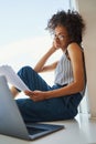 Woman in wire-rimmed circle eyeglasses scrutinizing documents