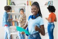 Young african american female student with dreadlocks and group of young adults showing thumb up Royalty Free Stock Photo