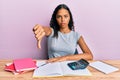 Young african american girl accountant working at the office looking unhappy and angry showing rejection and negative with thumbs