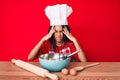 Young african american girl child with braids wearing professional cook apron with hand on head, headache because stress Royalty Free Stock Photo