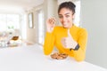 Young african american girl eating chocolate chips cookies as sweet snack happy with big smile doing ok sign, thumb up with Royalty Free Stock Photo