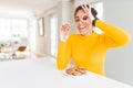 Young african american girl eating chocolate chips cookies as sweet snack with happy face smiling doing ok sign with hand on eye Royalty Free Stock Photo