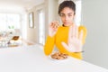 Young african american girl eating chocolate chips cookies as sweet snack with open hand doing stop sign with serious and Royalty Free Stock Photo