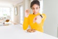 Young african american girl eating chocolate chips cookies as sweet snack pointing with finger to the camera and to you, hand Royalty Free Stock Photo