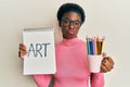 Young african american girl holding art notebook and colored pencils looking at the camera blowing a kiss being lovely and sexy Royalty Free Stock Photo