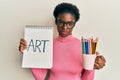 Young african american girl holding art notebook and colored pencils relaxed with serious expression on face Royalty Free Stock Photo