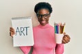 Young african american girl holding art notebook and colored pencils smiling with a happy and cool smile on face Royalty Free Stock Photo