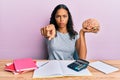 Young african american girl holding brain studying for school pointing with finger to the camera and to you, confident gesture