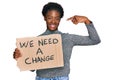 Young african american girl holding we need a change banner pointing finger to one self smiling happy and proud