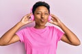 Young african american girl listening to music using headphones looking at the camera blowing a kiss being lovely and sexy Royalty Free Stock Photo