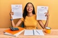 Young african american girl showing failed and passed exam smiling and laughing hard out loud because funny crazy joke Royalty Free Stock Photo