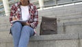 Young african-american girl sitting on stairs and writing poems, creativity