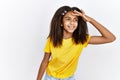 Young african american girl standing over white isolated background very happy and smiling looking far away with hand over head Royalty Free Stock Photo