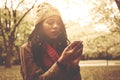 African American girl standing in park and typing on mobi