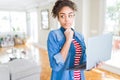 Young african american girl standing working using laptop serious face thinking about question, very confused idea Royalty Free Stock Photo