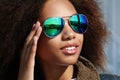 Young african american girl in sunglasses, posing outdoors, Dressed casual, with short voluminous hair. Royalty Free Stock Photo