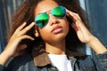 Young african american girl in sunglasses, posing outdoors, Dressed casual, with short voluminous hair. Royalty Free Stock Photo