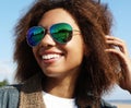 Young african american girl in sunglasses, posing outdoors, Dressed casual, with short voluminous hair. Royalty Free Stock Photo