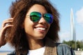 Young african american girl in sunglasses, posing outdoors, Dressed casual, with short voluminous hair. Royalty Free Stock Photo