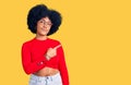 Young african american girl wearing casual clothes and glasses pointing with hand finger to the side showing advertisement, Royalty Free Stock Photo