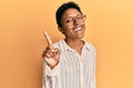 Young african american girl wearing casual clothes and glasses smiling with an idea or question pointing finger up with happy Royalty Free Stock Photo