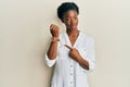 Young african american girl wearing casual clothes in hurry pointing to watch time, impatience, looking at the camera with relaxed