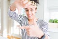 Young african american girl wearing golden queen crown on head smiling making frame with hands and fingers with happy face Royalty Free Stock Photo