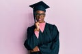 Young african american girl wearing graduation cap and ceremony robe with hand on chin thinking about question, pensive expression Royalty Free Stock Photo