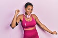 Young african american girl wearing gym clothes and using headphones dancing happy and cheerful, smiling moving casual and Royalty Free Stock Photo