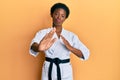 Young african american girl wearing karate kimono and black belt looking at the camera blowing a kiss being lovely and sexy Royalty Free Stock Photo