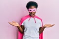 Young african american girl wearing superhero mask and cape costume celebrating crazy and amazed for success with arms raised and