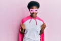 Young african american girl wearing superhero mask and cape costume celebrating surprised and amazed for success with arms raised