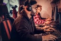 A young African American guy, enjoying spending time with his friends, playing in a multiplayer video game on a PC in a