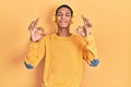 Young african american guy listening to music using headphones relaxed and smiling with eyes closed doing meditation gesture with Royalty Free Stock Photo