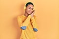 Young african american guy listening to music using headphones sleeping tired dreaming and posing with hands together while Royalty Free Stock Photo