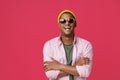 Young African-American guy, man in UK, Great Britain flag sunglasses, standing with arms folded wearing pink shirt and Royalty Free Stock Photo